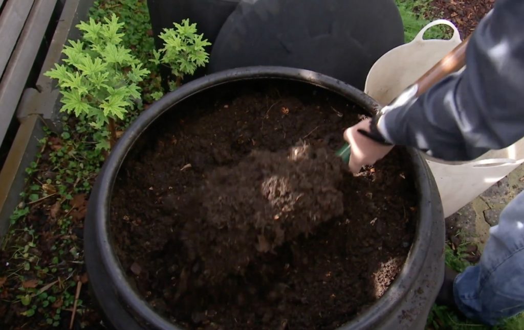 Mixing compost into top soil to make sand into fertile soil